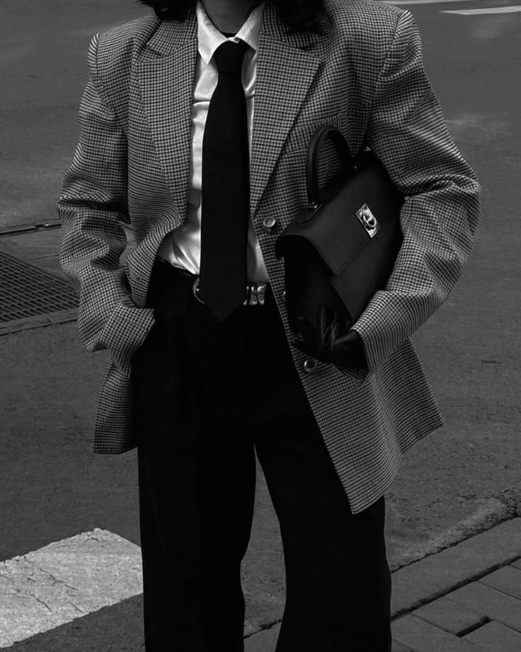 UHNI woman in tailored boardroom outfit holding a structured handbag