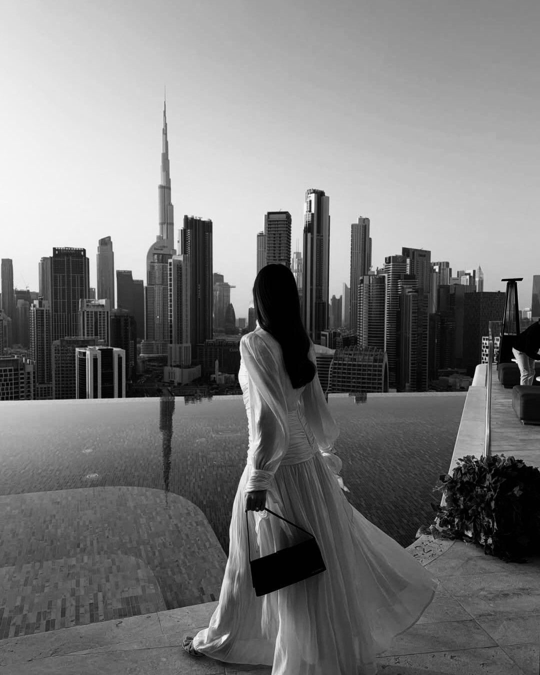 Woman overlooking the Dubai skyline while planning a second-address wardrobe