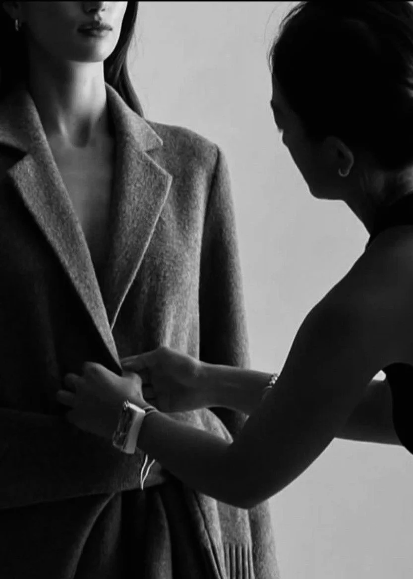 Stylist adjusting a tailored coat during a personal styling appointment
